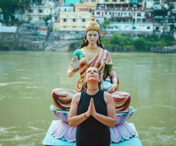 Person meditating outdoors with a calm natural background.